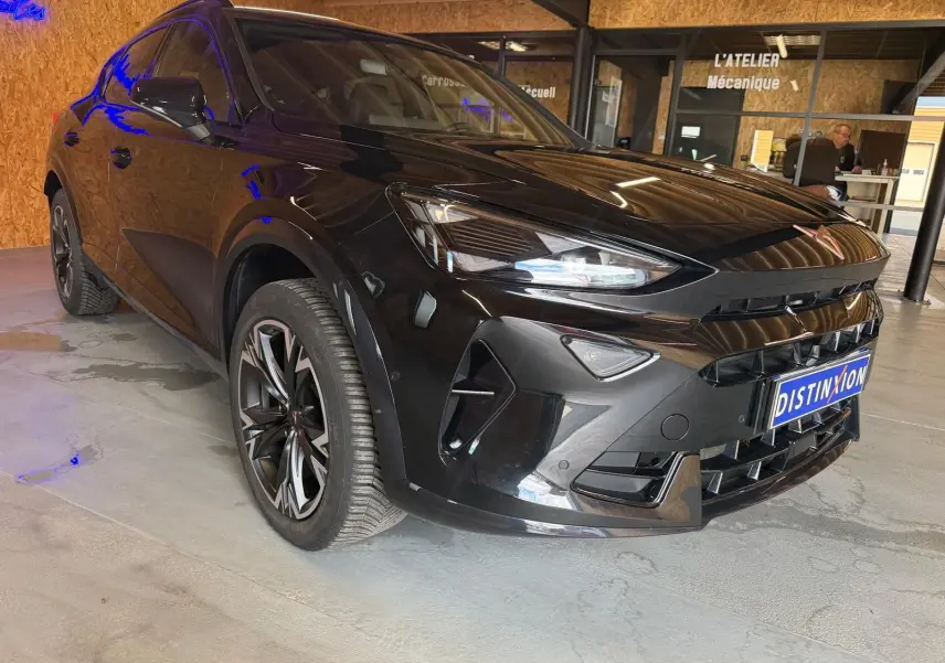Vue 3/4 avant gauche d'un CUPRA Formentor noir 2025 avec jantes alliage et calandre distinctive en intérieur showroom.