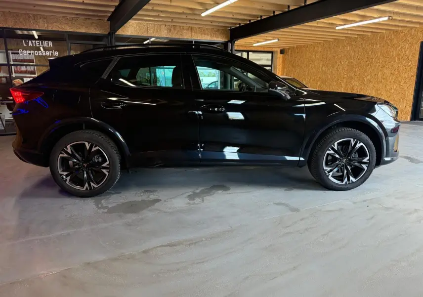 Vue de profil côté gauche du CUPRA Formentor noir 2025 avec jantes alliage 18'' et rétroviseurs rabattables électriques.
