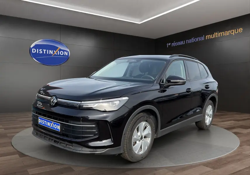 Volkswagen Tiguan noir vue 3/4 avant droit en intérieur avec calandre et phares LED distinctifs.