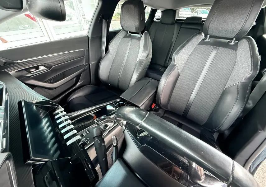 Intérieur noir de la Peugeot 308 SW 2018, vue côté conducteur montrant sièges et console centrale moderne.
