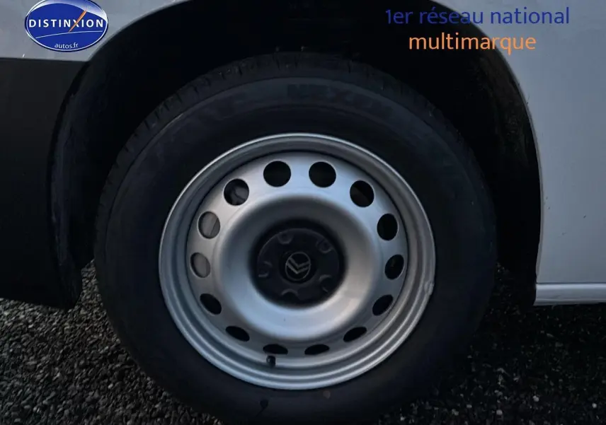 Gros plan sur la roue avant droite d’un Citroën Berlingo Fourgon blanc, avec jante acier grise et logo Citroën au centre.