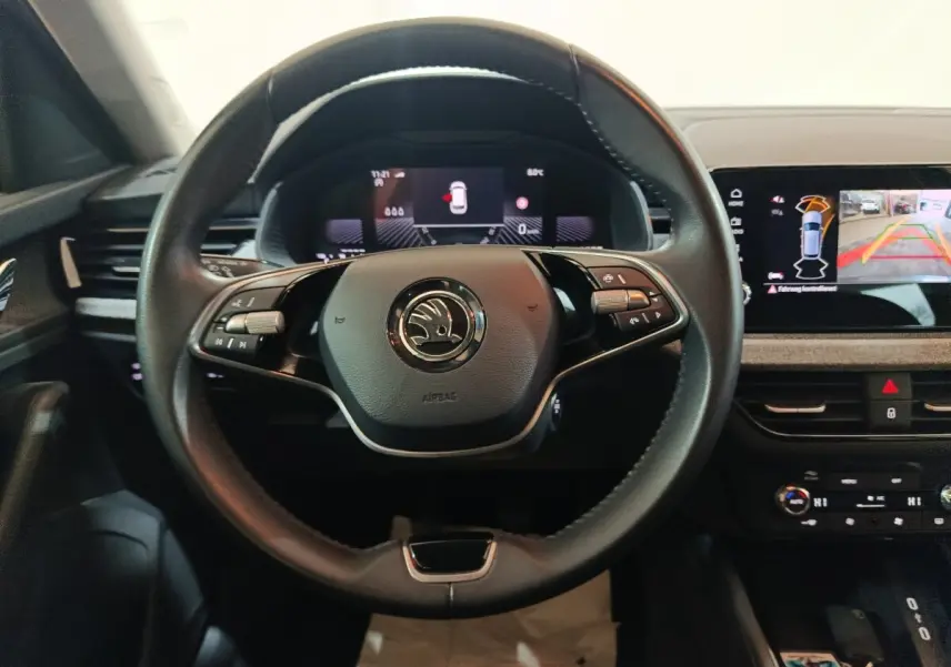 Vue frontale du volant cuir multifonctions noir et des écrans digitaux du tableau de bord du Skoda Kamiq gris clair 2024.