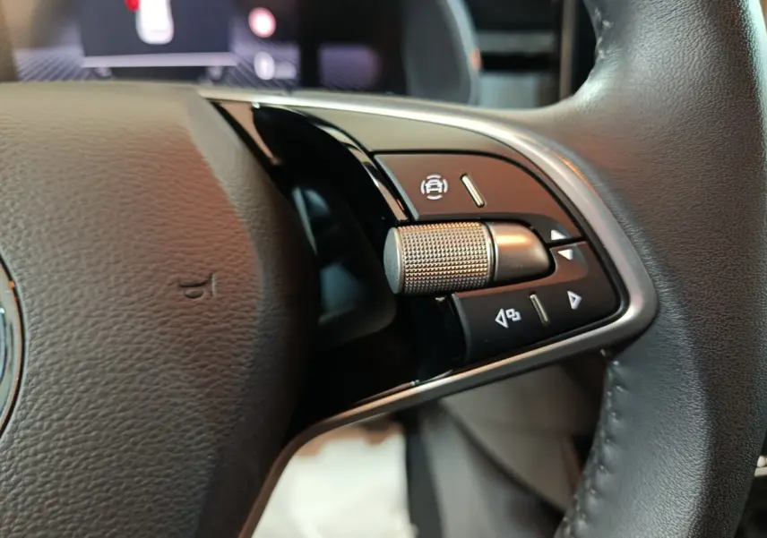 Gros plan sur le volant cuir multifonctions du Skoda Kamiq 2024, côté droit avec molette et boutons de contrôle.