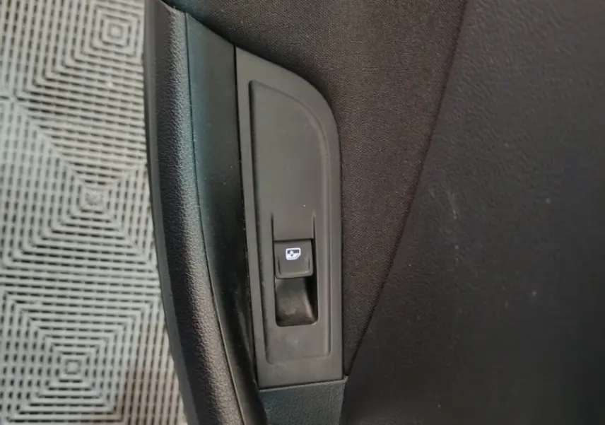 Gros plan sur le bouton de verrouillage des portes côté intérieur d'une Skoda Kamiq gris clair 2024.