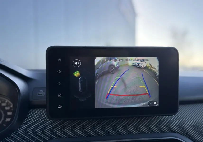Écran tactile intérieur du Dacia Jogger gris schiste montrant la caméra de recul avec guidage de trajectoire coloré.