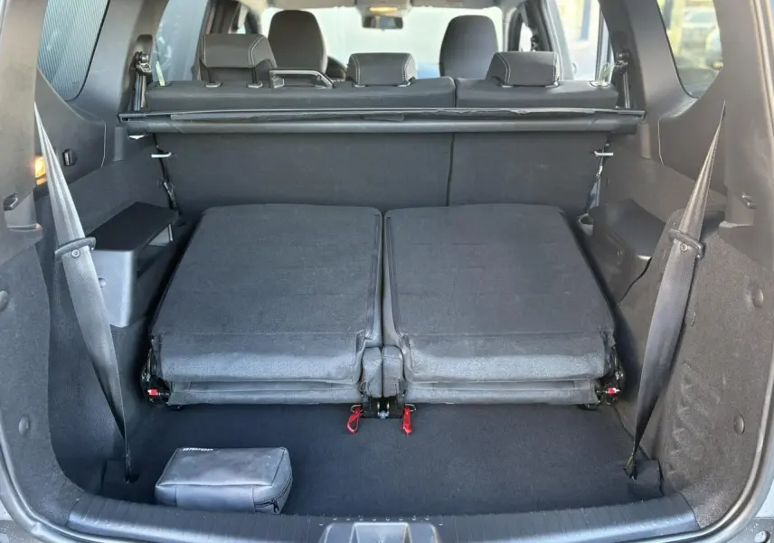Vue arrière du coffre du Dacia Jogger gris Schiste 2025 avec sièges rabattus au troisième rang et espace de chargement dégagé.