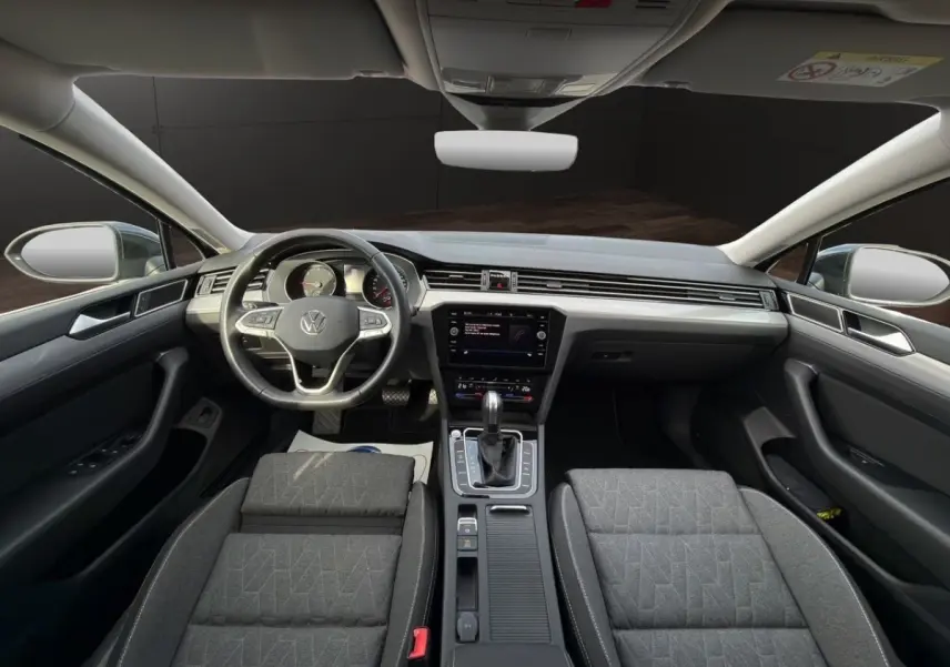 Vue intérieure avant de la Volkswagen Passat 2.0 TDI 2022 avec tableau de bord moderne et sièges gris foncé.