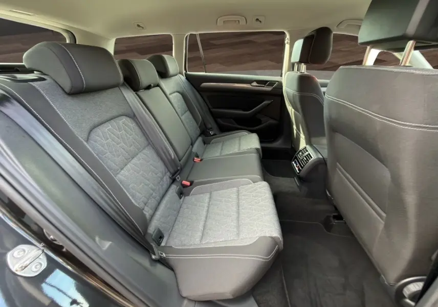 Vue intérieure des sièges arrière gris clair et noir d'une Volkswagen Passat 2022, avec aérateurs centraux visibles.