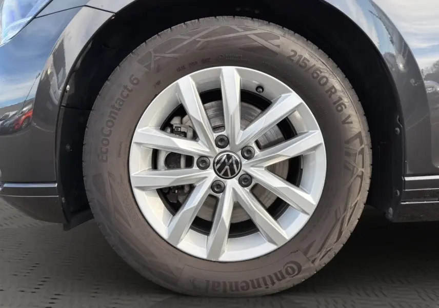 Gros plan sur la roue avant droite gris foncé d'une Volkswagen Passat 2.0 TDI avec jante alliage argentée et logo VW central.