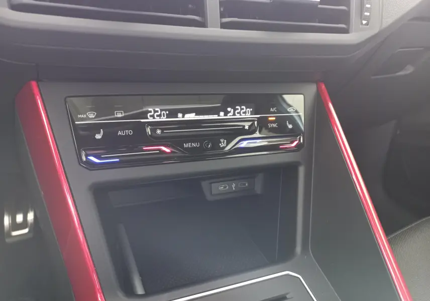 Vue rapprochée de la console centrale de la Volkswagen Polo GTI 2024, avec éclairage rouge et bleu et détails rouges décoratifs.