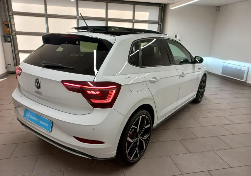 Volkswagen Polo GTI blanc pur vue 3/4 arrière droit avec toit noir et jantes alliage 18 pouces en intérieur.