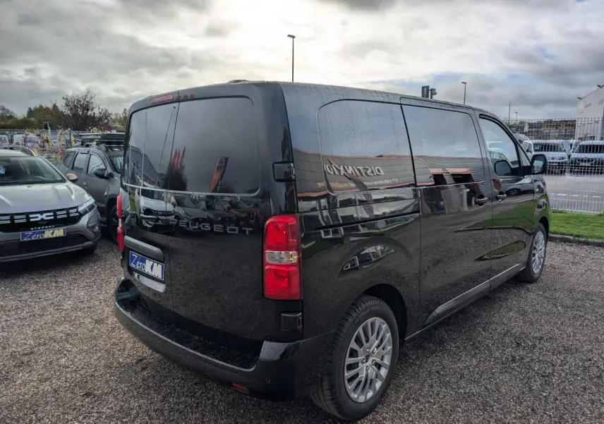 Vue 3/4 arrière droite d'un Peugeot Expert Fourgon noir brillant avec vitres teintées et jantes alliage.