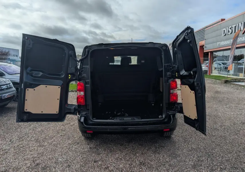 Vue arrière du Peugeot Expert Fourgon noir 2025 avec portes ouvertes montrant l'espace de chargement vide.