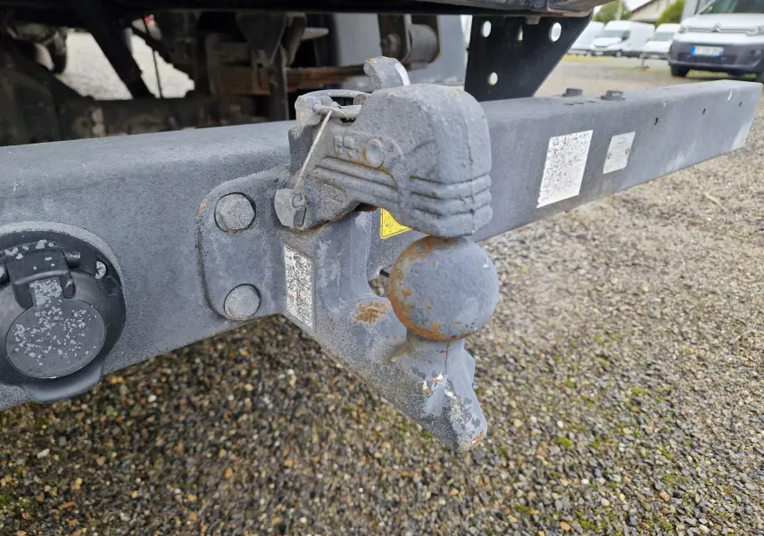 Gros plan sur l'attelage arrière gris métallique du camion blanc Iveco Daily Chassis Cabine 35C14 avec benne et grue.