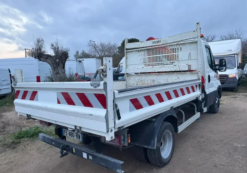 IVECO Daily Chassis Cabine blanc vu 3/4 arrière droit avec benne et grue Palfinger, marquages rouges et blancs.