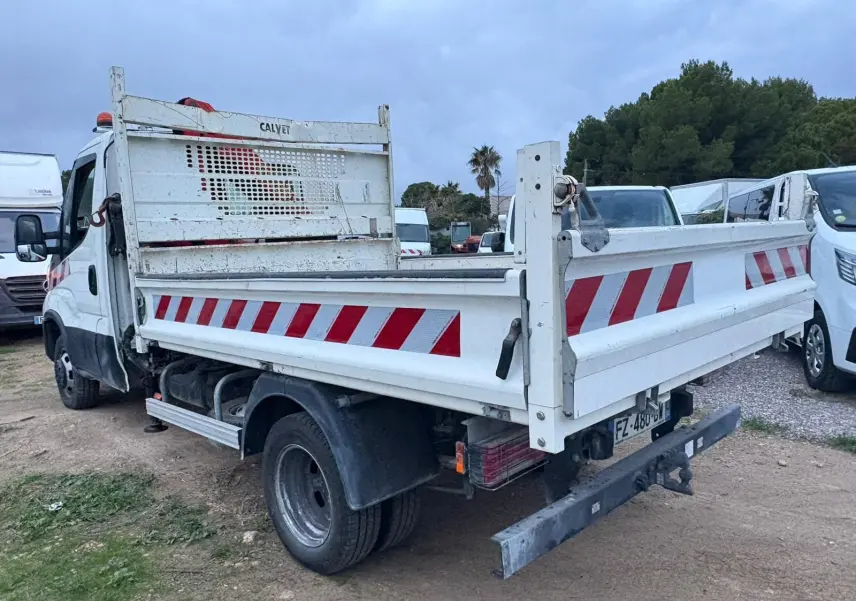 IVECO Daily Chassis Cabine blanc vu en 3/4 arrière droit avec benne basculante et marquages rouges réfléchissants.