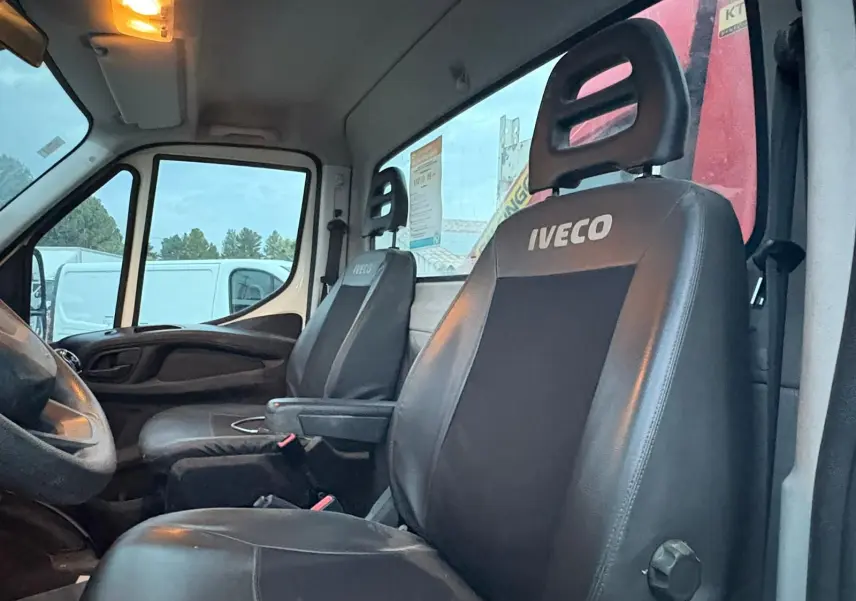 Vue intérieure côté conducteur de l’Iveco Daily 35C14 2021, sièges noirs avec logo Iveco visibles.