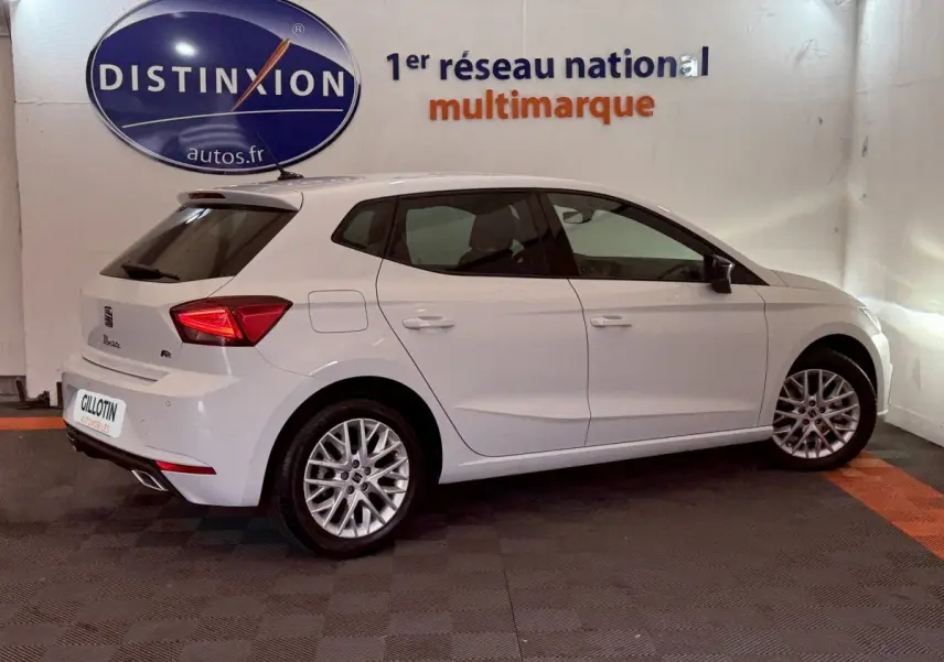 SEAT Ibiza 1.0 TSI 110 FR blanche vue de profil droit en intérieur, avec jantes alliage et feux arrière LED.
