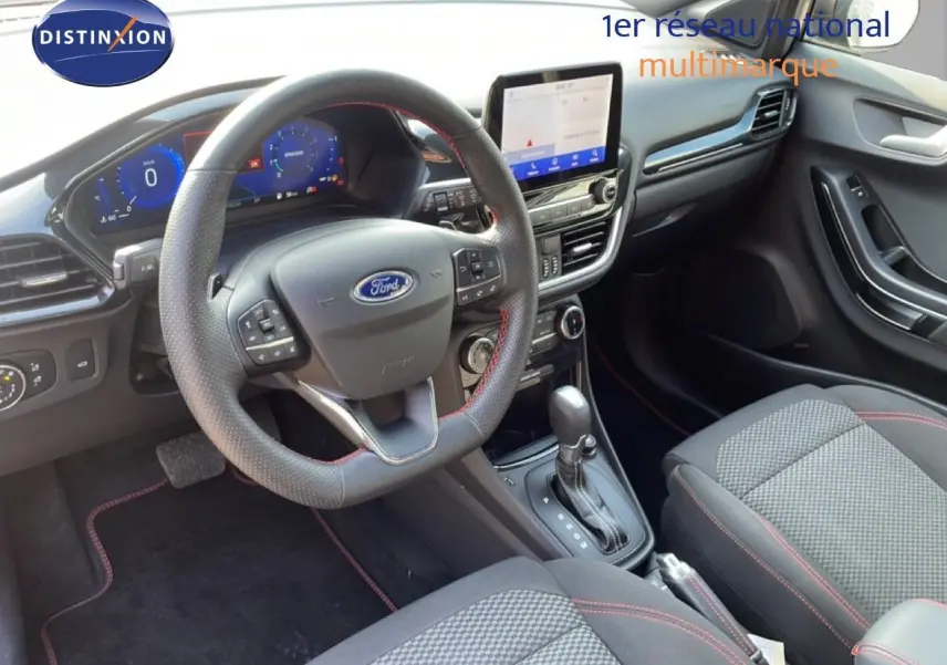 Vue intérieure côté conducteur du Ford Puma 2023 noir agate, volant cuir, tableau de bord digital et console centrale moderne.