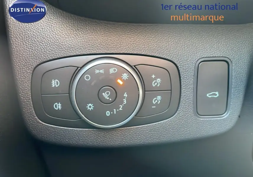 Gros plan sur le panneau de commandes d’éclairage et ouverture du coffre du Ford Puma noir Agate 2023, intérieur noir texturé.