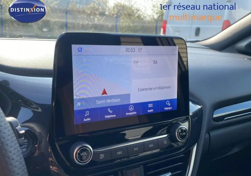 Vue intérieure centrée sur l'écran tactile du système multimédia du Ford Puma noir agate métal, avec tableau de bord moderne.