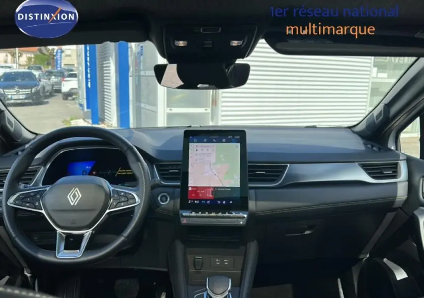 Vue intérieure avant du Renault Symbioz blanc 2025, mettant en valeur le tableau de bord moderne avec écran tactile vertical.