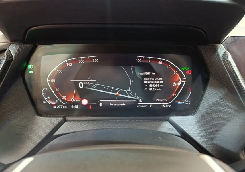 Vue rapprochée du tableau de bord numérique de la BMW Série 1 noire, affichant la vitesse et la navigation.