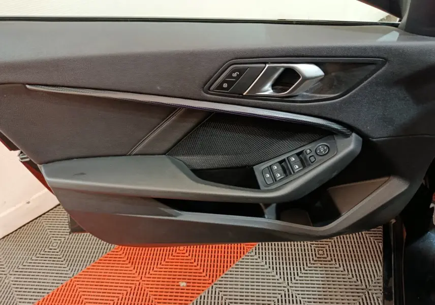 Vue rapprochée de la porte avant gauche noire de la BMW Série 1 118i Edition Sport avec commandes électriques.
