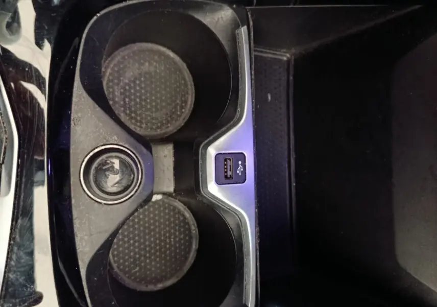 Vue plongeante sur le porte-gobelets noir brillant avec prise USB intégré dans une BMW Série 1 118i Edition Sport 2023.