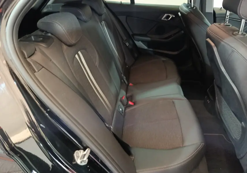 Vue intérieure côté gauche des sièges arrière noirs en tissu et cuir de la BMW Série 1 118i Edition Sport 2023.