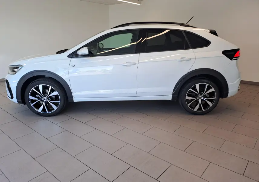 Vue de profil côté gauche du Volkswagen Taigo blanc pur 2025 avec jantes alliage noir et argent 18 pouces R-Line Edition.