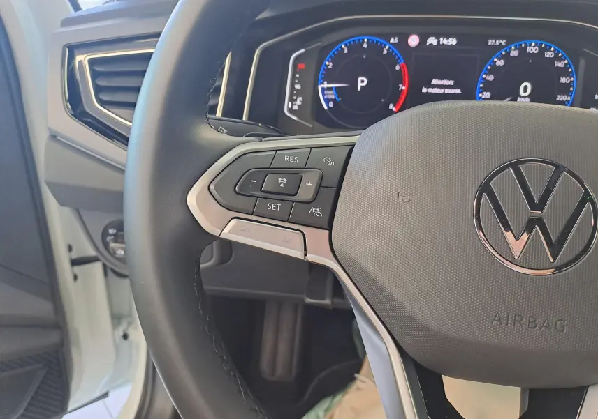 Gros plan sur le volant multifonctions et le tableau de bord numérique du Volkswagen Taigo 1.0 TSI blanc, version R-Line Edition.