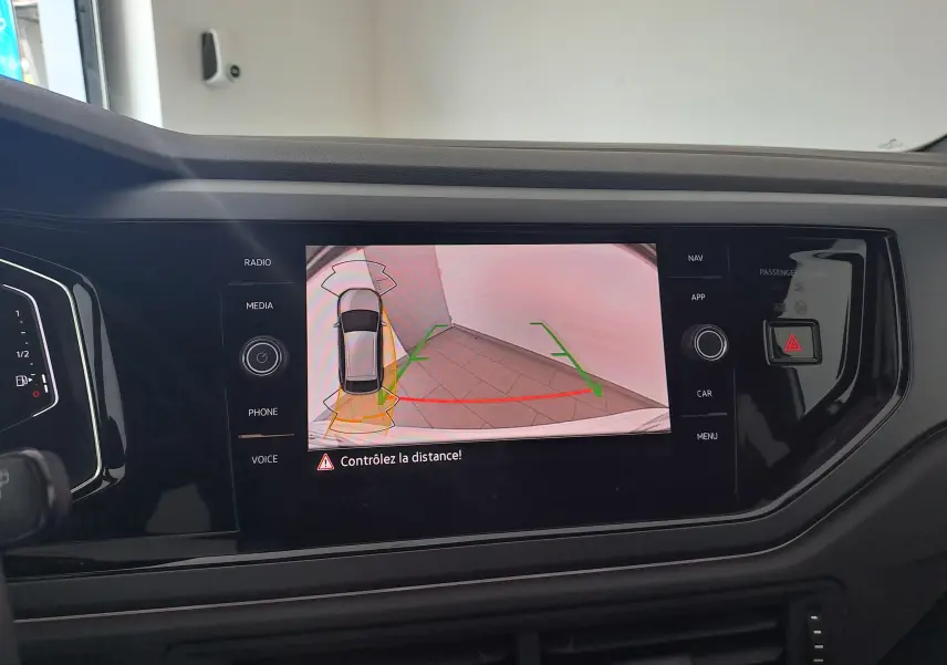 Vue intérieure sur l'écran central du Volkswagen Taigo blanc, affichant la caméra de recul avec guidage dynamique.