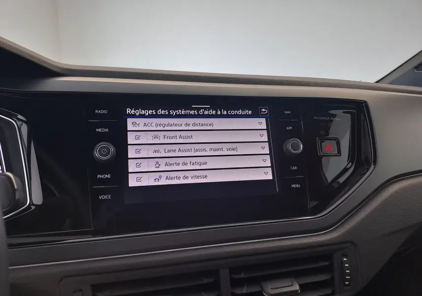 Écran tactile central du Volkswagen Taigo 2025 affichant les réglages des aides à la conduite dans un intérieur noir.