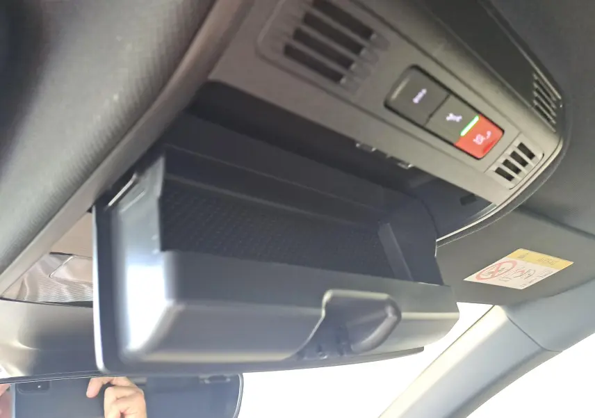 Rangement lunettes ouvert sous le plafonnier avec boutons SOS et assistance dans un Volkswagen Taigo blanc 3/4 avant intérieur.