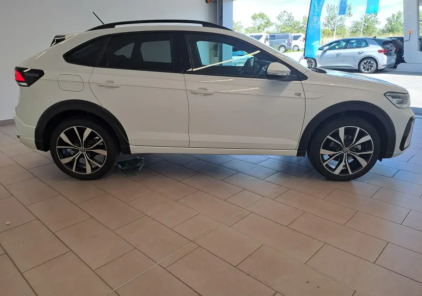 Vue de profil côté gauche du Volkswagen Taigo blanc pur 2025 avec jantes alliage 18 pouces et badge R-Line.