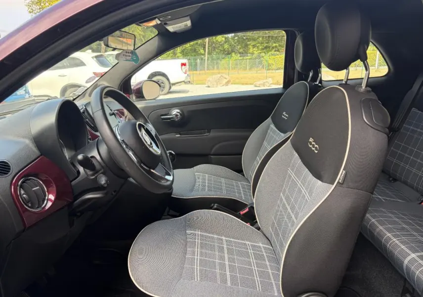 Intérieur de la FIAT 500 violet vue côté conducteur, sièges à motif écossais avec logo 500 brodé, volant cuir multifonctions.