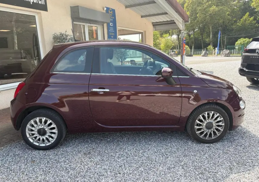 Profil côté gauche d'une FIAT 500 berline violet foncé 2019 avec jantes alliage et rétroviseurs assortis.