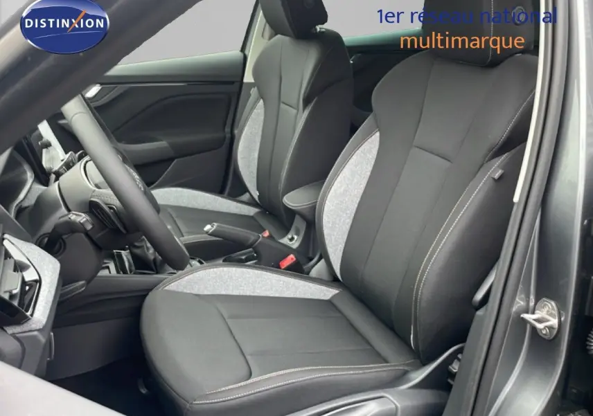 Vue intérieure côté conducteur du Skoda Kamiq 2025 avec sièges tissu noir et gris clair, volant et tableau de bord visibles.