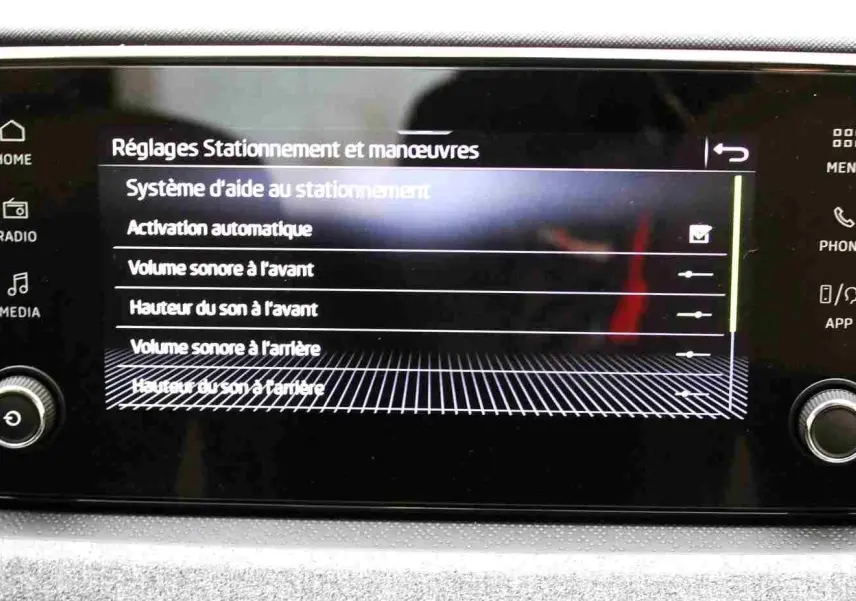 Écran tactile central du Skoda Kamiq 2025 affichant les réglages d'aide au stationnement avec commandes physiques autour.