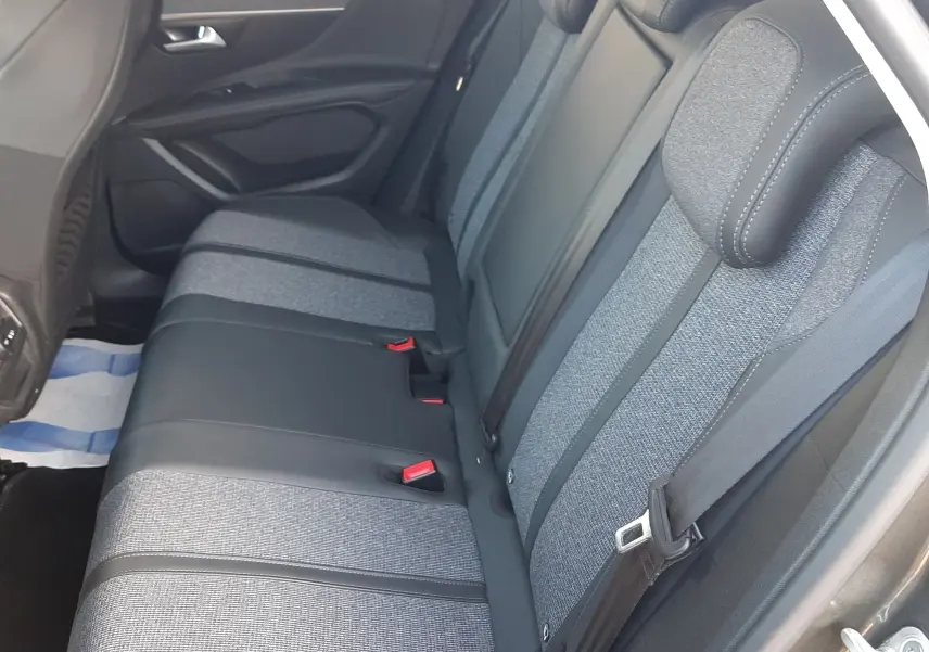 Vue intérieure côté droit des sièges arrière du Peugeot 3008 gris Amazonite, avec sellerie tissu et cuir noir.