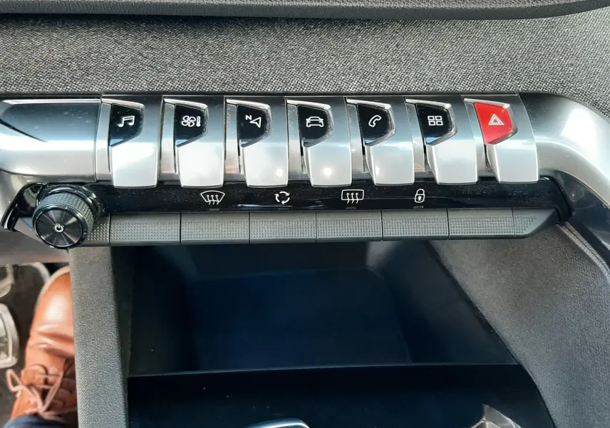 Vue rapprochée de la console centrale du Peugeot 3008 gris Amazonite, montrant les boutons de commande et le levier de boîte automatique.