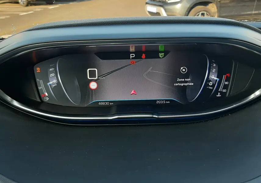 Vue rapprochée du tableau de bord numérique du Peugeot 3008 gris Amazonite, affichant la vitesse et la navigation.