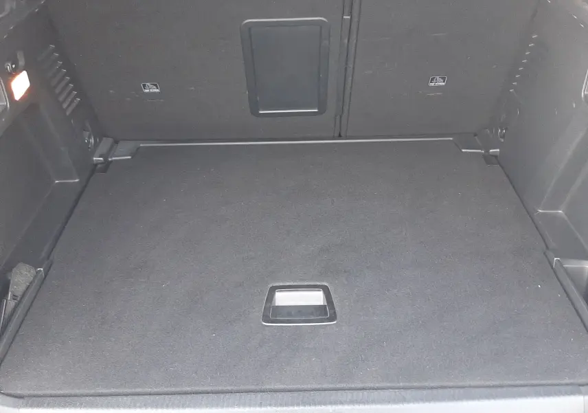 Coffre vu de l'arrière d'un Peugeot 3008 gris Amazonite, espace de chargement propre et bien aménagé.
