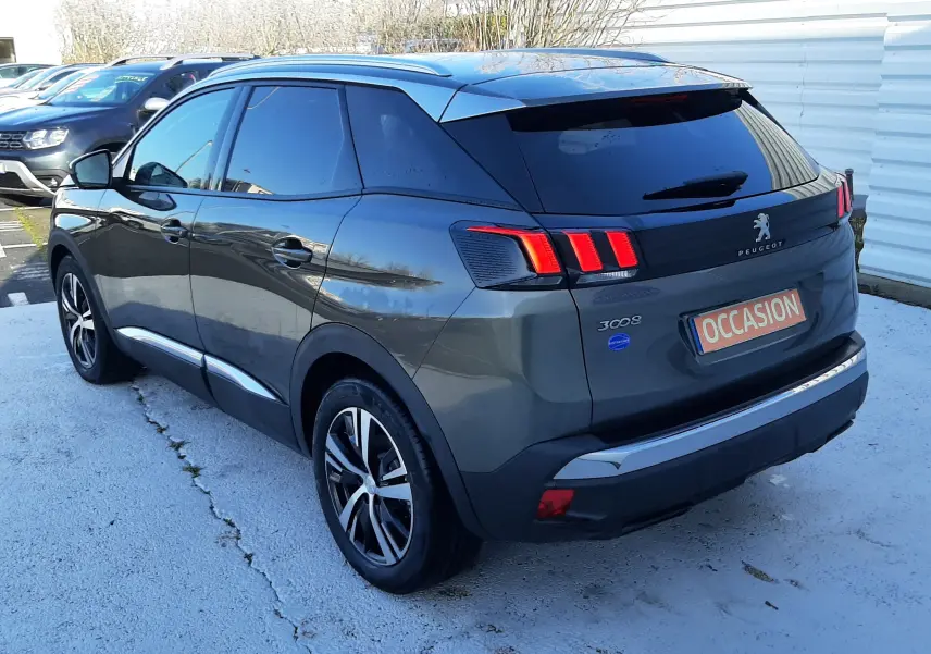 Vue 3/4 arrière droite d'un Peugeot 3008 gris amazonite avec feux arrière à trois griffes et jantes alliage bicolores.