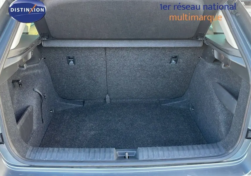 Coffre ouvert du Skoda Kamiq gris graphite métal 2024, vue arrière montrant l'espace de chargement vide et les finitions intérieures en tissu gris.