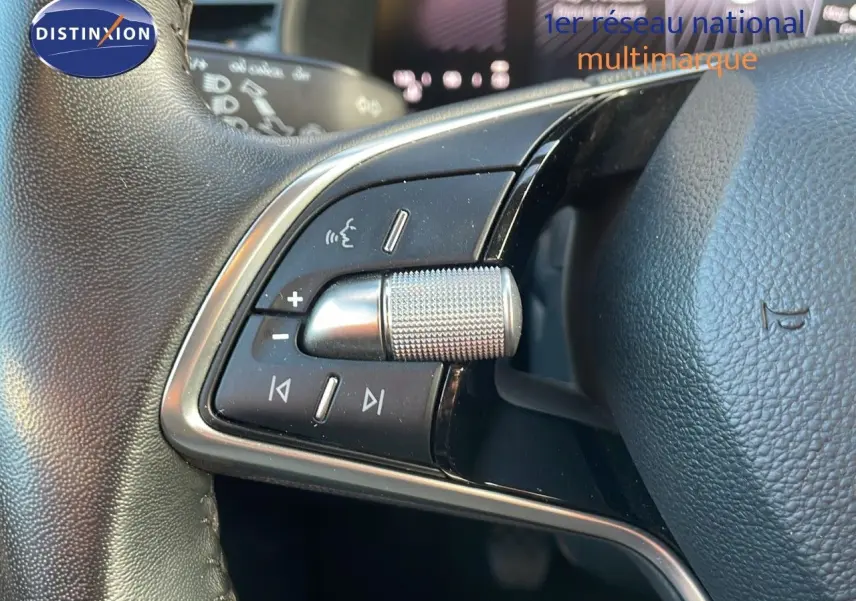 Gros plan sur les commandes au volant du Skoda Kamiq gris graphite, mettant en valeur la molette de réglage et les boutons multifonctions.