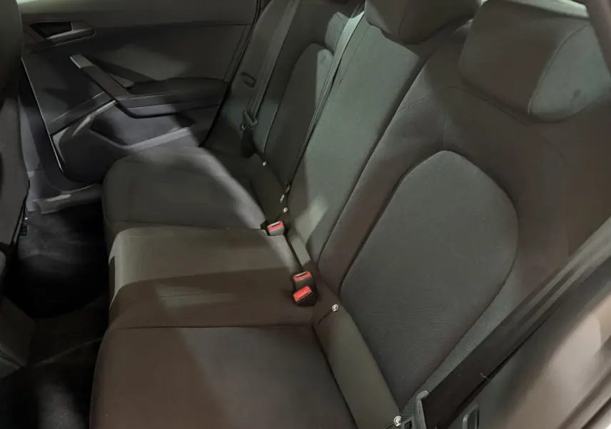 Vue intérieure des sièges arrière noirs de la SEAT Ibiza 2024, avec banquette 3 places et ceintures visibles.