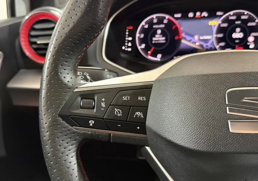 Gros plan sur le volant cuir et alu de la SEAT Ibiza 2024 avec commandes multifonctions et tableau de bord numérique.