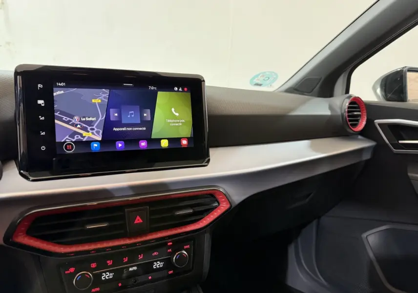 Vue intérieure côté passager du tableau de bord de la SEAT Ibiza blanc avec écran tactile et aérateurs rouges.